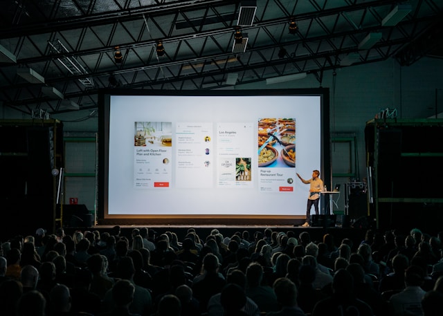 Professional presentation showing website mockups on a large screen